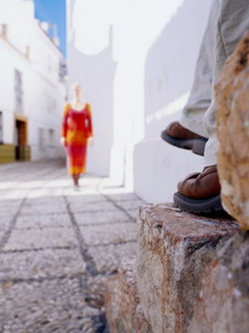 Woman Approaching Man Sitting on Step in Lane, Nerja, Spain