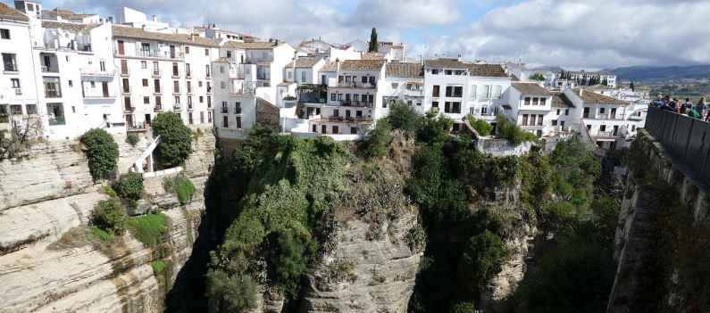 House cling to the edge of the cliffs in Ronda, Spain